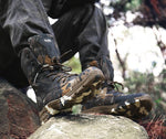 Soldat assis portant une paire de chaussures camouflage militaire aux pieds avec des lacets