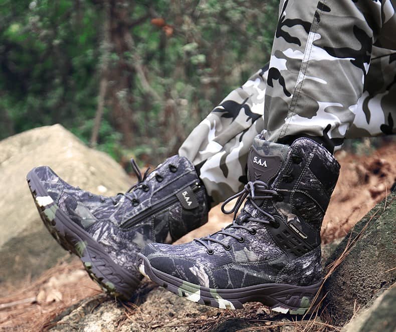 Seated soldier wearing a pair of camouflage military shoes.